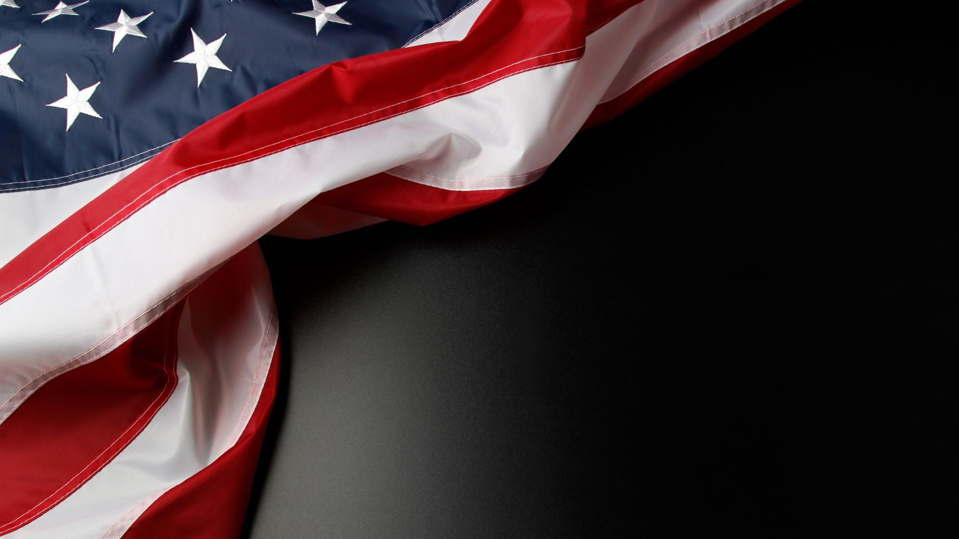 Dark textured background with an American flag design behind Blackout Coffee products