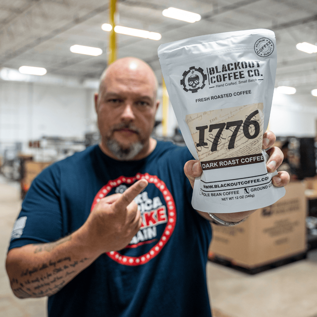 1776 dark roast man holding the coffee bags