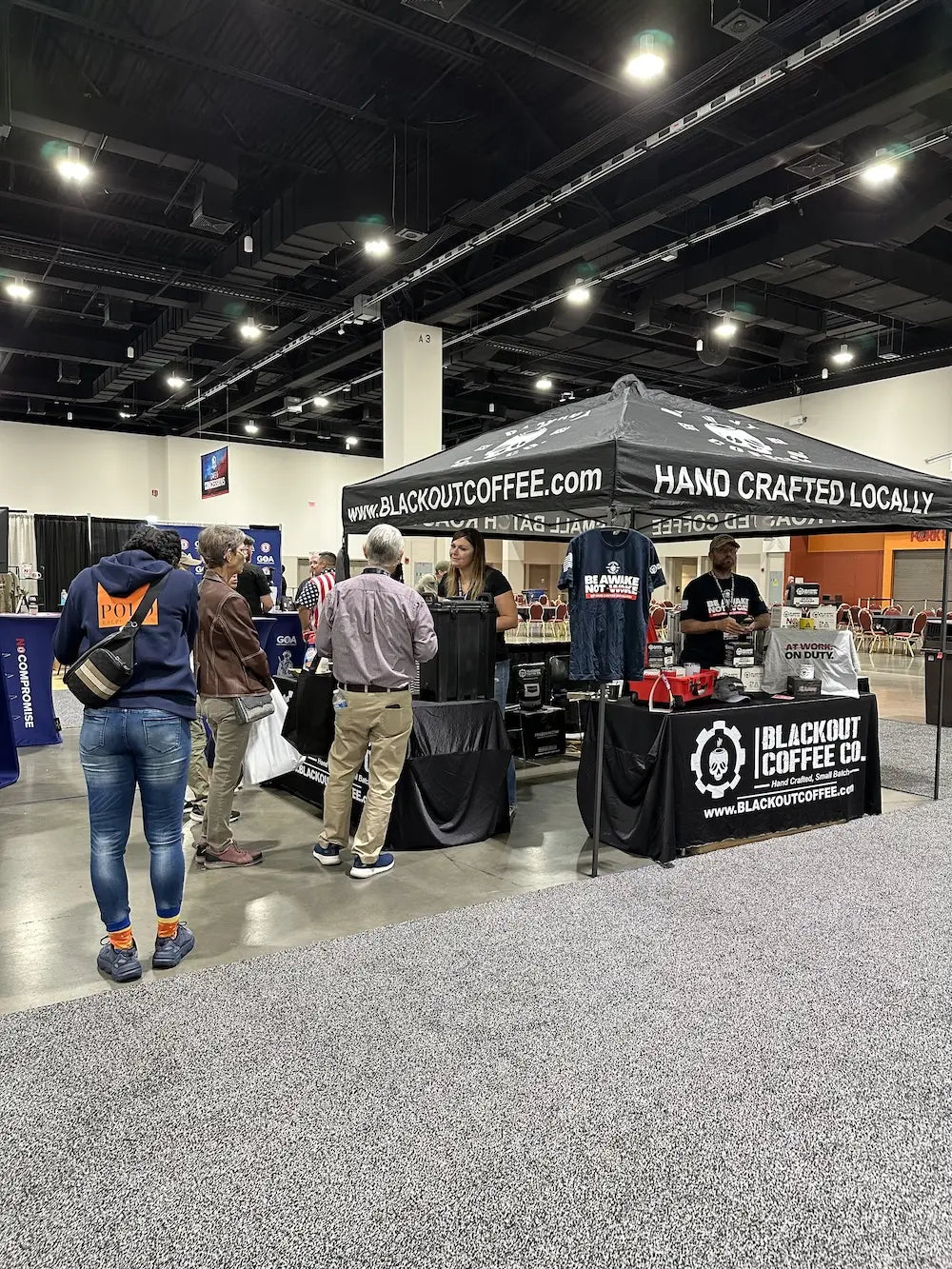 Blackout Coffee representatives speaking with visitors at an event