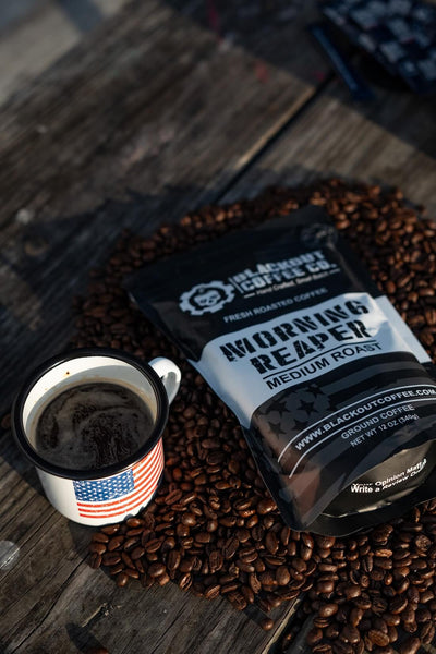 Blackout Coffee Co. Morning Reaper coffee bag with a cup of coffee on a wooden surface.