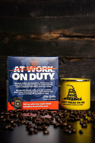 Blackout Coffee Co. packaging and mug on a wooden surface with coffee beans.