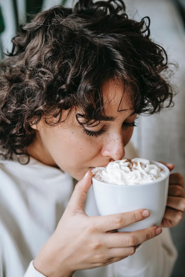 Person enjoying a mug of hot cocoa