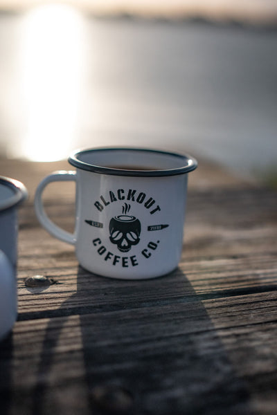 White mug with 'Blackout Coffee Co.' logo on a wooden surface