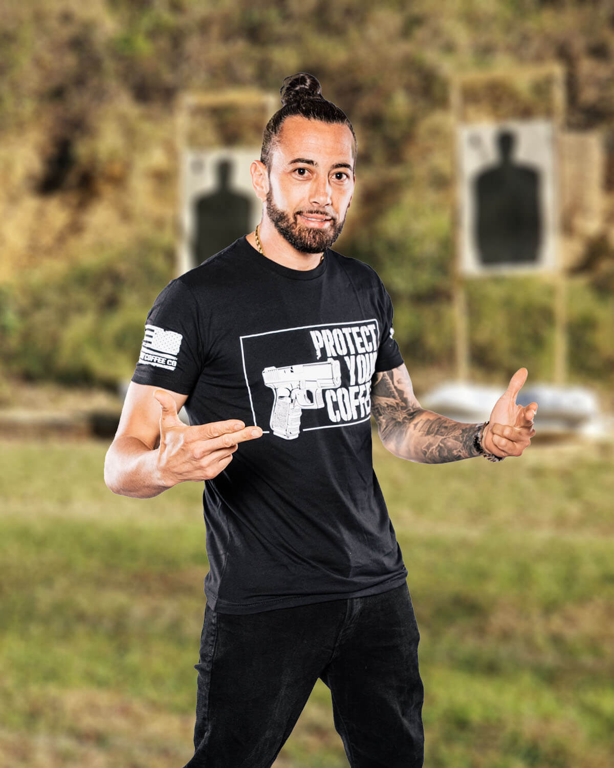 Man wearing a black t-shirt with a graphic design, standing outdoors with a blurred background.