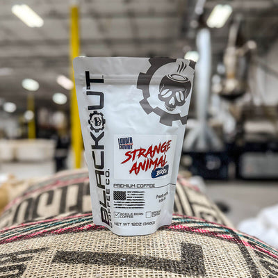 Strange Animal coffee package on a burlap bag with a blurred warehouse background