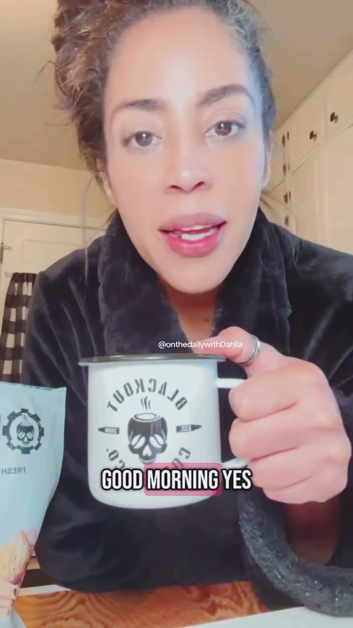 Blackout Coffee customer holding a fresh cup beside an identifiable coffee bag